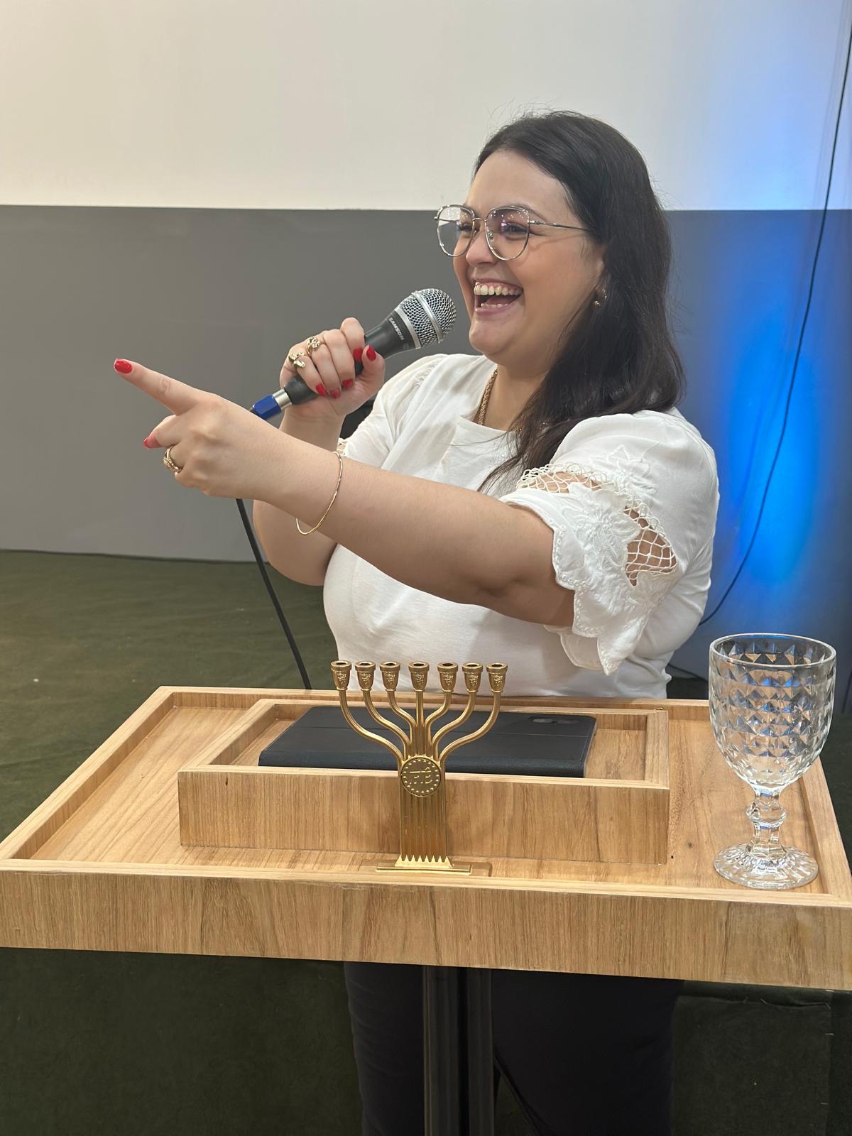 Karine com microfone durante uma ministração