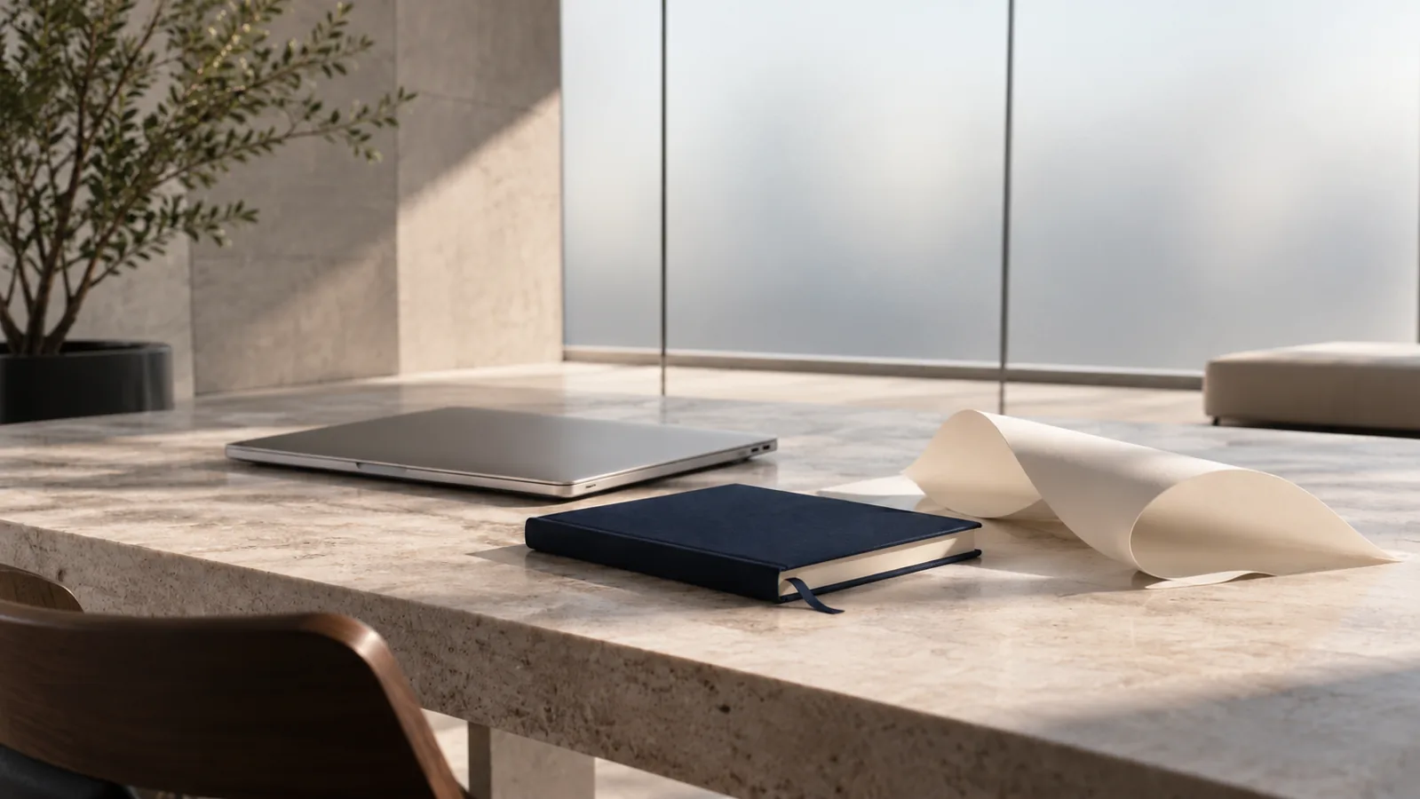 Planejamento e criação: caderno azul, computador e papel em composição minimalista.